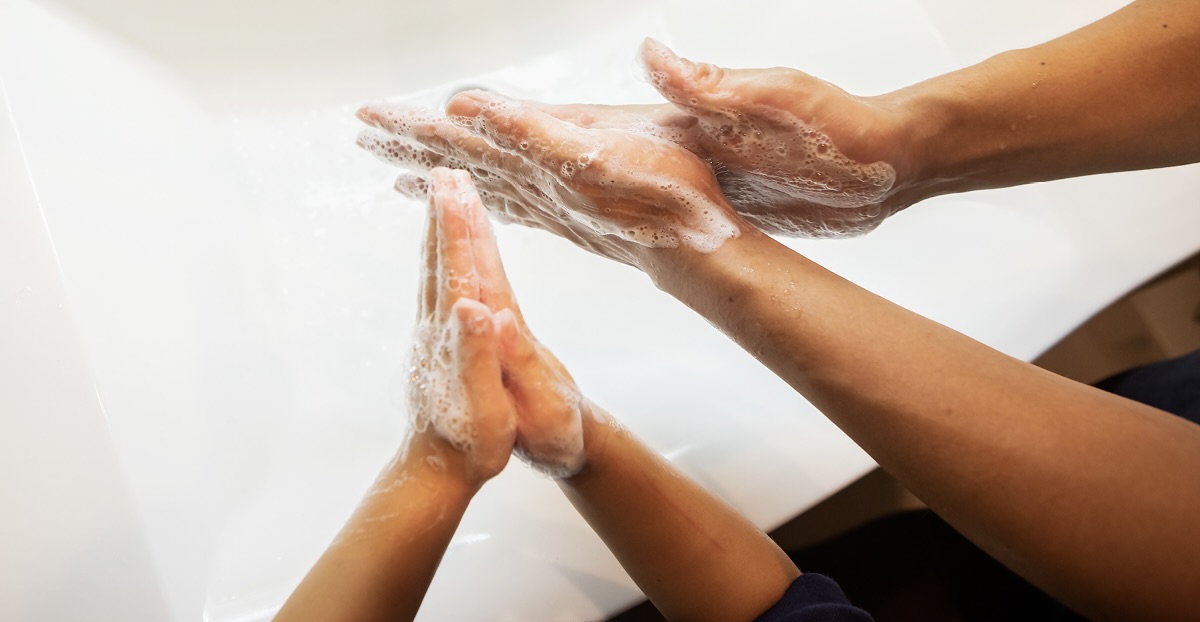 Two people washing their hands with soap