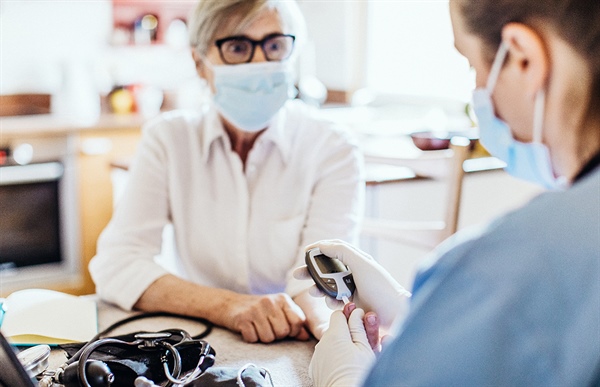 A woman getting her diabetes levels checked by a healthcare professional