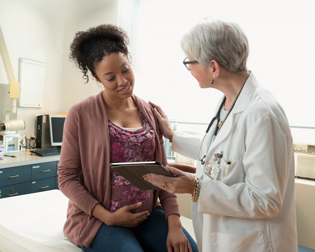 Pregnant woman talking with doctor