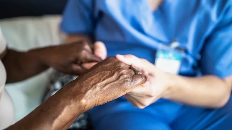Nurse holding a person's hands