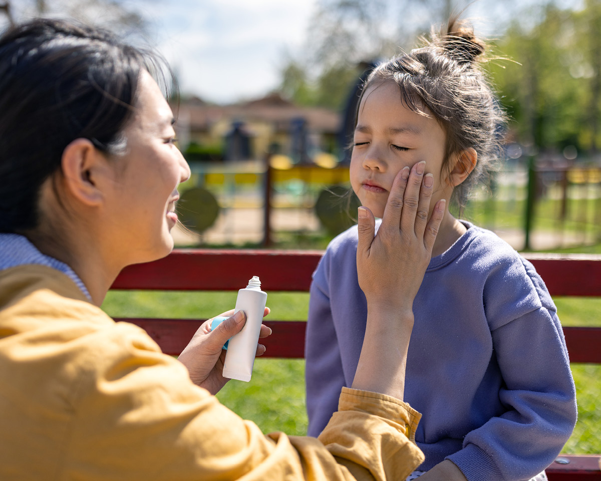 Parent applying sunscreen to child.